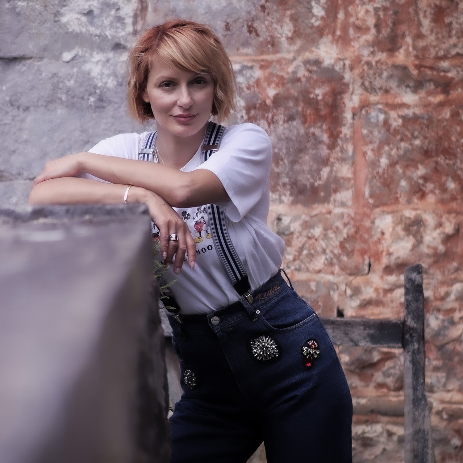 woman-leaning-on-wall-wearing-blue-elastic-wiseguy-suspenders